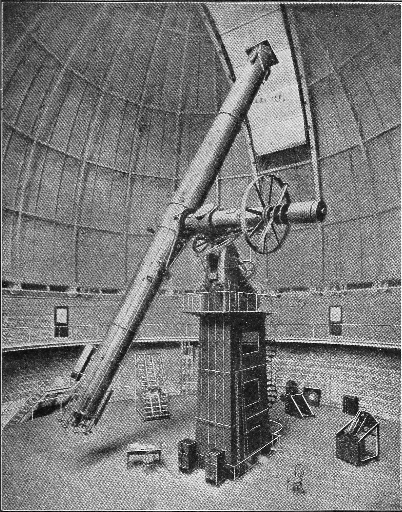 Fig. 12.—Great Telescope of the Yerkes Observatory, mounted by Warner & Swazey. — A photograph inside the dome: the long tube of the great telescope slants up toward the open slit, carried on its axes and a large wheel atop a tall iron pier.