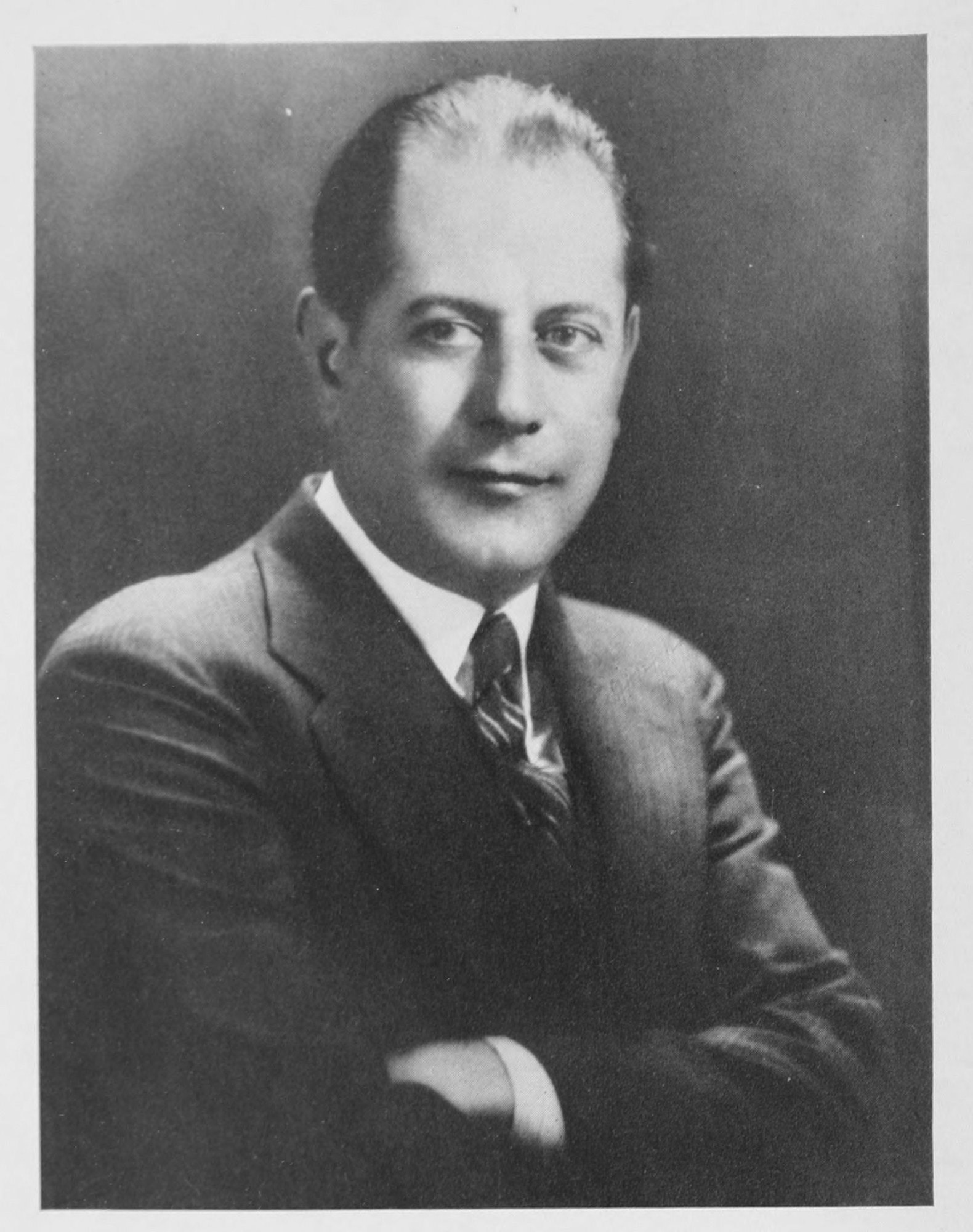 José R. Capablanca — A studio photograph of the author, turned a little to the left in a dark suit, white shirt and striped tie, his arms folded, looking into the camera with a slight smile.
