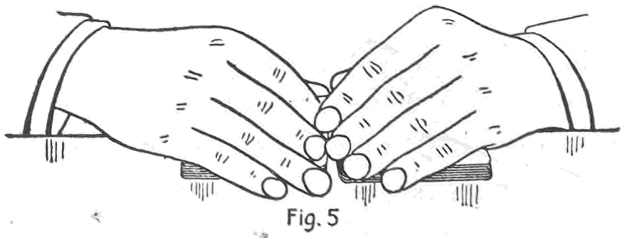 Fig. 5. — The top stock riffle begun: two packets end to end on the table, both hands resting on their outer ends, the left first and second fingers covering the in-jogged top card of the left packet.