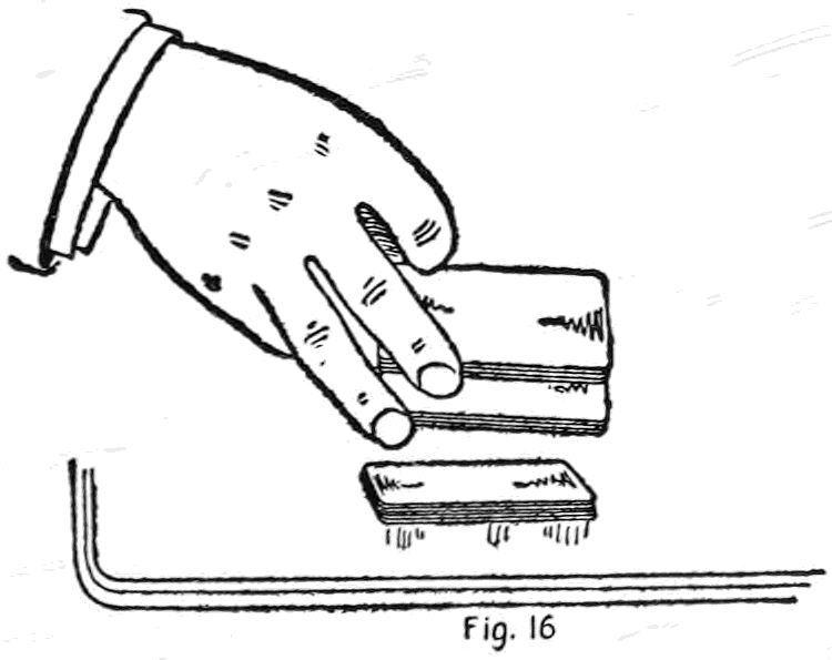 Fig. 16. — The one-handed fancy true cut: the right hand holds the deck near the end, the second finger tip hooking up the top portion free of the third finger; a packet lies on the table below.