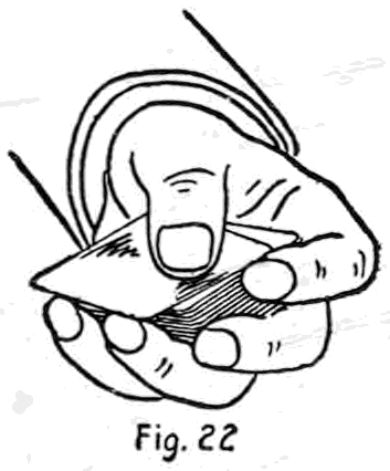 Fig. 22. — The hold for bottom dealing: the deck held by its corners between the left second finger and the palm below the thumb, the thumb on top pointing toward the second finger tip.