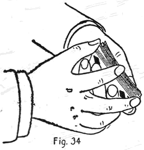 Fig. 34. — The right hand under-cuts to the out-jog while its thumb presses up on the in-jog card, forming and holding a break between the packets as the under packet is drawn out.