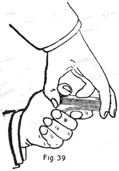 Fig. 39. — Bottom palm, first method: the right hand holds the deck on top by the ends while the left second finger grips the bottom cards at the corner and pulls them down past the right thumb.