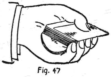 Fig. 47. — The left hand deals with the bottom palm held: the palmed cards lie in the left palm beneath the deck laid across them, concealed by the four fingers pressed close against its side.