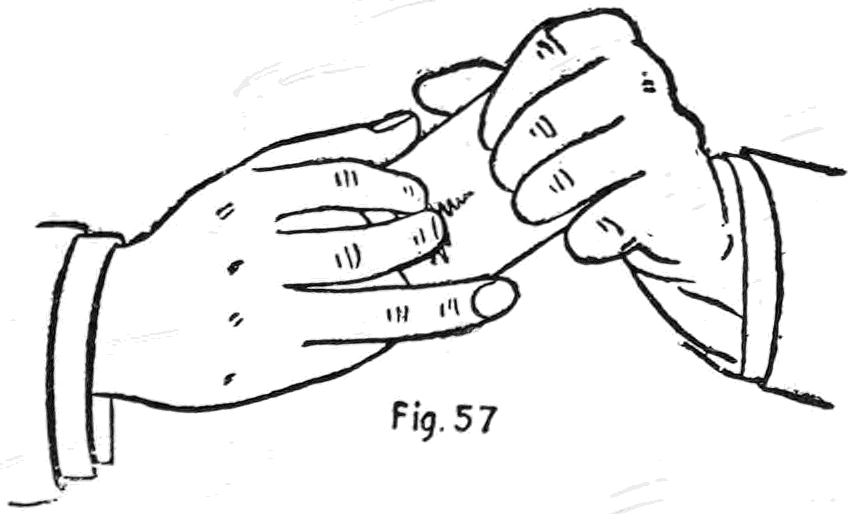 Fig. 57. — Reading the hand: the cards rest in the left hand, and the right hand is brought up with its thumb on top and fingers curled on the back, ready to open the edges.