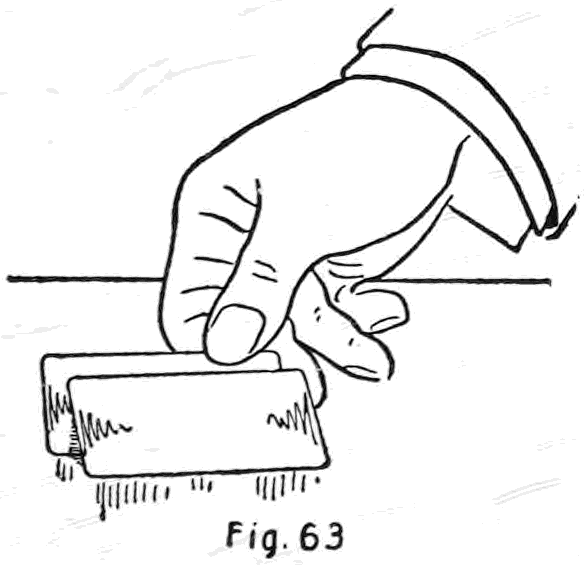 Fig. 63. — The right thumb and first finger slide the hand card under the right side of the card on the table until it is about two-thirds concealed.