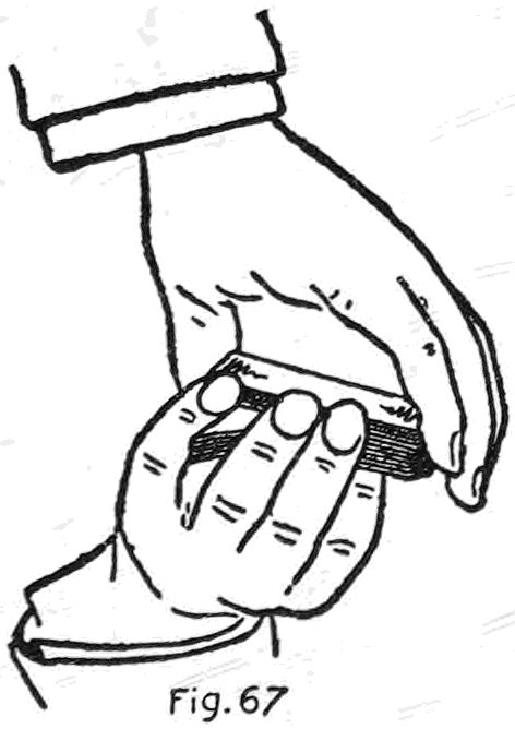Fig. 67. — The Longitudinal Shift prepared: the right hand covers the deck from above at the ends, while the left little finger is pressed in between the corners of the two packets at the inner end.