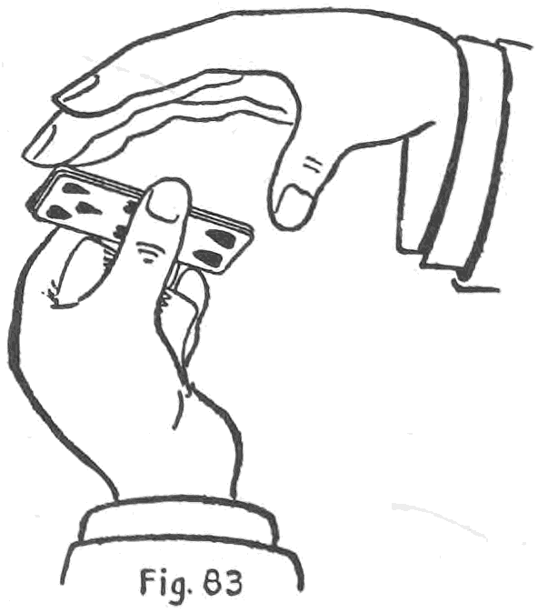 Fig. 83. — The Double-Palm Change: the left hand holds the face-up packet from the table by its sides between thumb and fingertips, as the right hand comes flat over it to palm it.