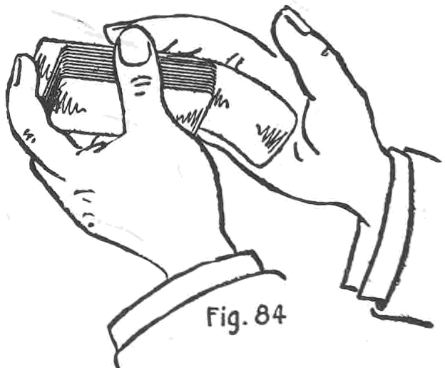 Fig. 84. — The First Method: the left hand holds the deck while the right palm presses against the selected card and draws it down past the wrong card, which is pushed up against the left first finger.