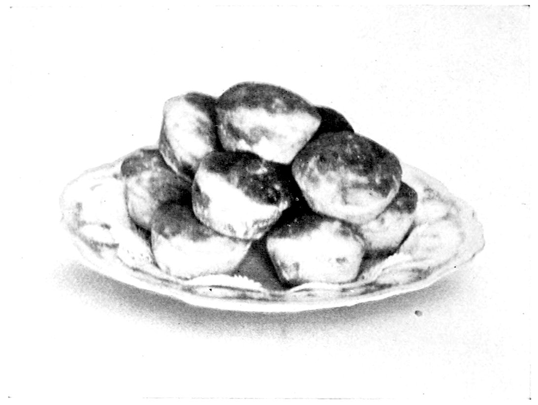 Raised Hominy Muffins. — A heap of Raised Hominy Muffins, browned and rounded on top, on an oval dish.