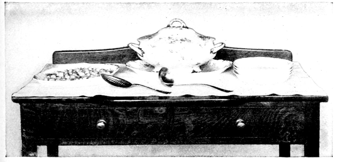 Cream Soup and Croûtons ready for serving. — A covered china soup tureen and ladle on a sideboard, with a stack of soup plates on one side and a dish of croûtons with a serving spoon on the other.