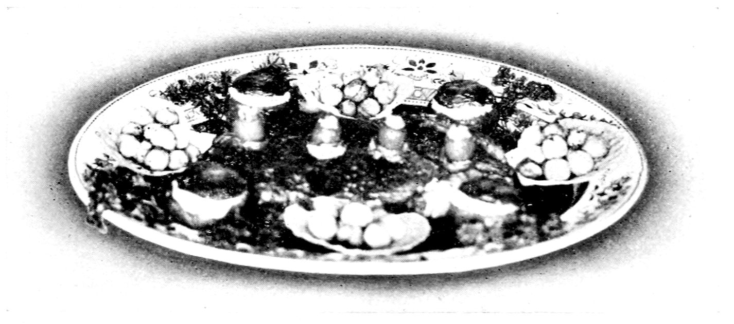 Beefsteak à la Mirabeau. — The steak lies at the centre of a large oval platter, ringed by stuffed tomatoes and by potato balls heaped in scalloped noodle shells, with sprays of parsley between them.