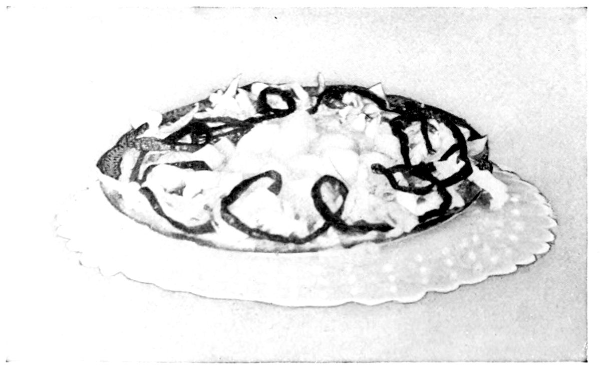 Pear Salad. — Pieces of pear on lettuce fill an oval dish, criss-crossed with thin curling ribbons of red pepper, the dish set on a scalloped paper doily.