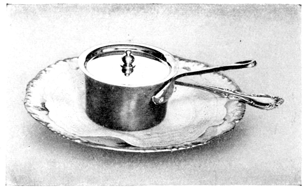 Oyster Crabs a la Newburg; Individual Service. — A small covered silver saucepan with a long handle and a knobbed lid stands on a plate lined with a doily, a serving spoon laid beside it.