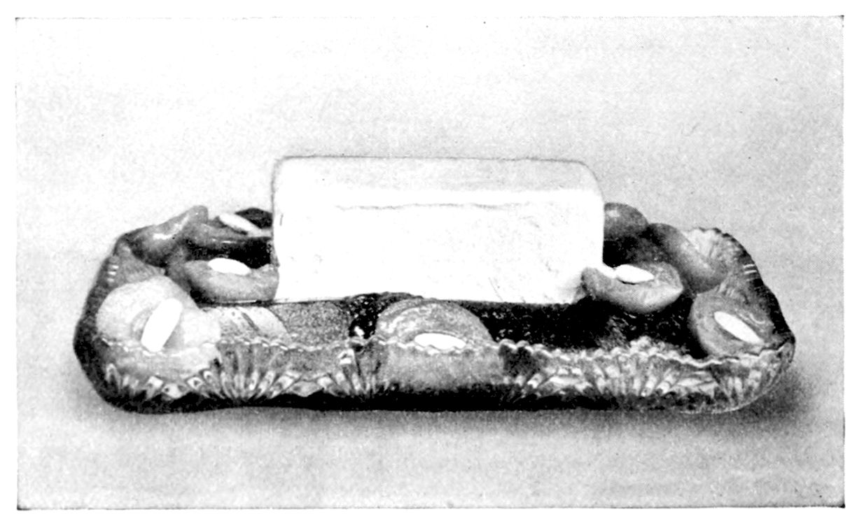 Junket Ice Cream with Peaches. — A brick of pale ice cream stands in the middle of a cut-glass tray, surrounded by peach halves with half a blanched almond in each hollow.