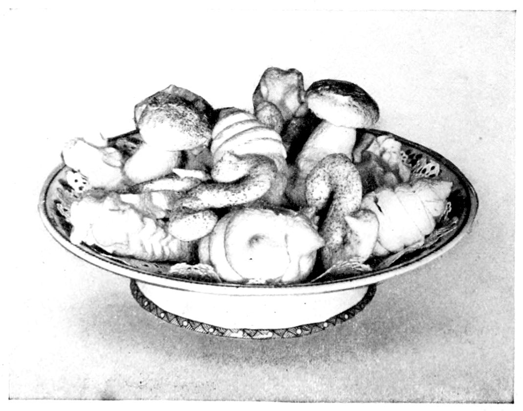 Meringues. — A footed bowl heaped with meringues piped in many shapes: mushrooms with speckled caps on white stems, rings, twists, rosettes and long ridged fingers.