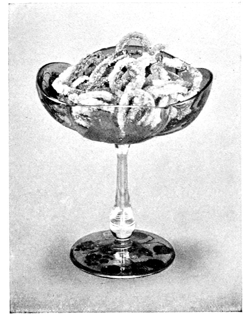 Candied Orange Peel. — Curling strips of orange peel, thickly crusted with sugar, heaped in a stemmed glass compote whose foot is painted with grapes and leaves.
