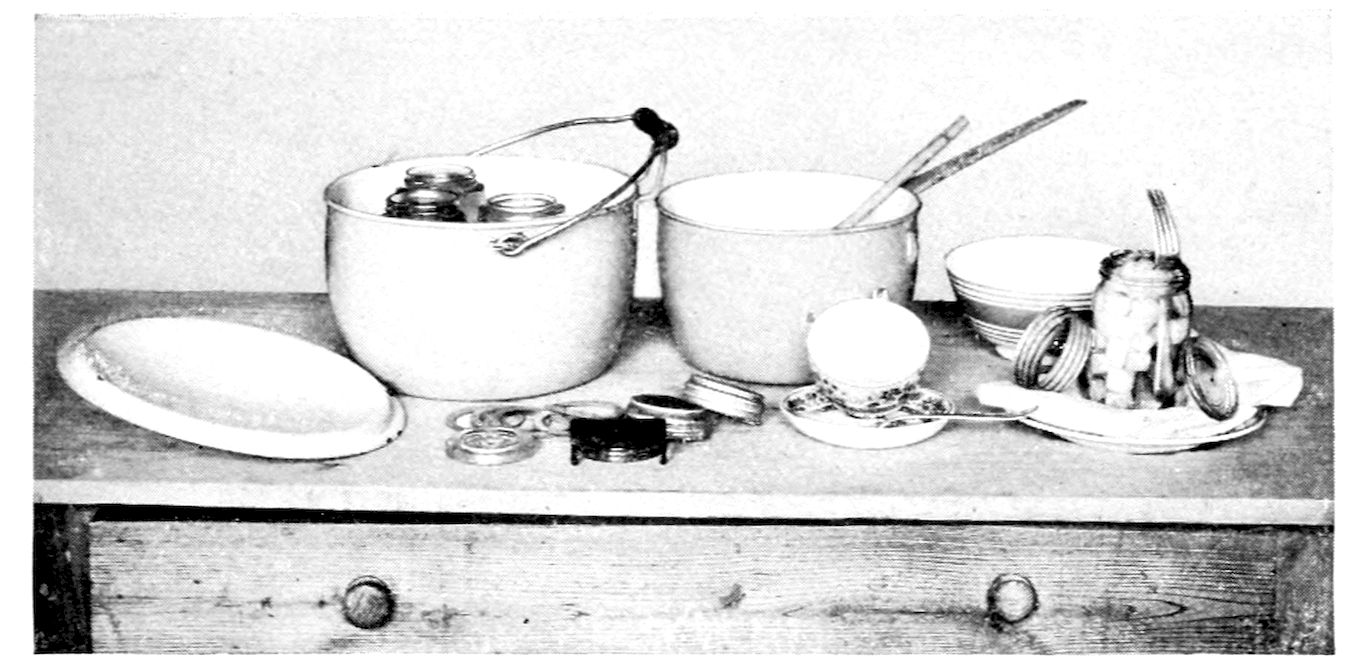 Utensils necessary for canning. — On a kitchen table: a large kettle with a bail handle holding glass jars, a second kettle with wooden spoons, a platter, bowls, jar rubbers and covers, a teacup and saucer, and an open jar with a funnel.