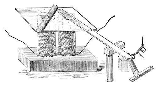 The great electromagnet, with a long bar of iron rising into position on one of its poles and lumps of iron hanging from the far end of the bar.