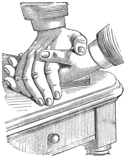 Fig. 30. — The performer's left hand lies back downwards on the pack on a table, and his right hand presses heavily upon it.
