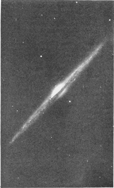 The Nebula Seen Edge-On. Note the central core which, through millions of years, is cooling to solidity. Photo: G. W. Ritchey — A long, thin streak of light crosses the dark sky diagonally, swelling at its middle into a bright core that is split along its length by a dark band.