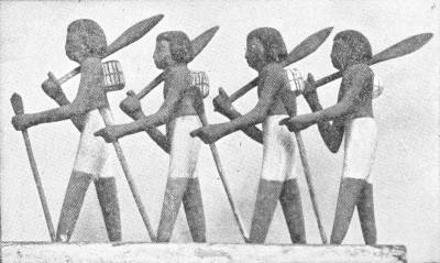 Egypt Peasants Going to Work. From an ancient and curiously painted model in the British Museum — A wooden model of four men walking in single file, each with a hoe over his shoulder, a staff in hand and a small basket hanging behind.