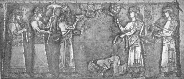 Another Panel of the Black Obelisk. Captive Princes making obeisance to Shalmaneser II — A carved stone panel in which a man kneels with his face to the ground before the king, who stands with attendants behind him under a winged disc and a star; two robed figures stand on the right.