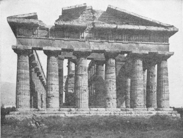 The Temple of Neptune (Poseidon), Pæstum, Sicily. Photo: Alinari — A Doric temple still standing almost entire, its double row of fluted columns carrying the entablature and both pediment ends, on a grassy site.