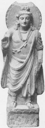 Statuette of Maitreya: the Buddha to Come. A Græco-Buddhist sculpture of the Third Century A.D. (From Malakand, N. W. Province, now in the India Museum) — A standing stone figure with a halo behind his head, a tall knot of hair and heavy necklaces, wearing a draped robe, with his right hand raised.