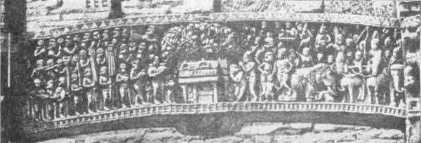 Transome Showing the Court of Asoka. India Mus. — A long curved stone beam carved with a dense crowd of figures, with a small shrine at the centre and elephants and horsemen on the right.