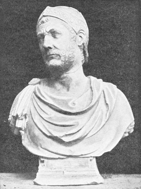 Hannibal. Bust in the National Museum at Naples. Photo: Mansell — A marble bust of a bearded man with a furrowed brow, wearing a close-fitting decorated cap or helmet and a cloak draped over his shoulders.