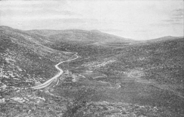 The Road from Nazareth to Tiberias. Photo: Fannaway — A road winds up a valley between bare, stony hills, empty of people or buildings.
