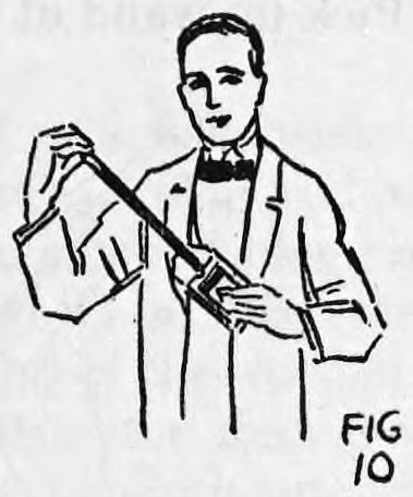 Fig. 10. — A smiling man in a suit holds the card case in his left hand and draws the wand out of it with his right.