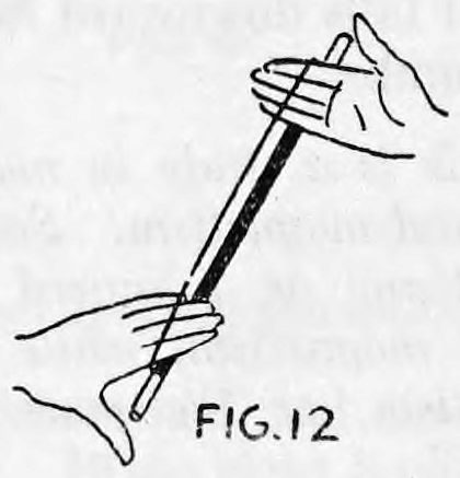 Fig. 12. — The wand slanting upward with the left fingertips placed on it under the loop of thread, and the right hand lower down.