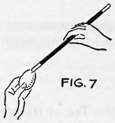 Fig. 7. — A hand holds the wand upright and taps its tip against the end of an egg held in the other hand.
