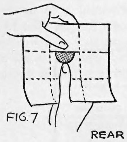 Fig. 7. — Rear view: the left hand holds the paper by its pocket while the right thumb, beneath the pocket opening, lets the coin slide out toward the center.
