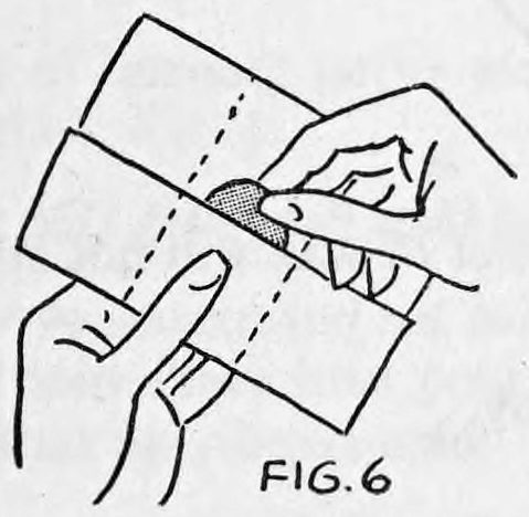 Fig. 6. — The paper with its bottom third brought up, held in the left hand while the right hand pushes the coin edge against the slot, as the audience sees it.