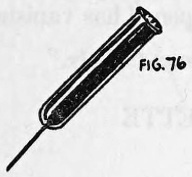 Fig. 76. — The cigarette pull shown with the cigarette seated in its mouth and the elastic cord trailing from the lower end.