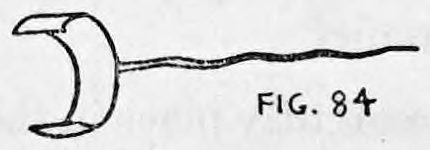 Fig. 84. — The cigarette clip seen from the side: a curved flesh-colored metal band that fits over the finger, with a long thin pin extending from it.