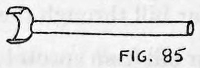 Fig. 85. — The cigarette clip seen from above, the curved band at the left and the long straight pin running to the right.