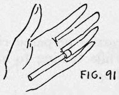 Fig. 91. — The back of the left hand with the Cigarette Clip at the base of the third finger and the cigarette extending down toward the palm.