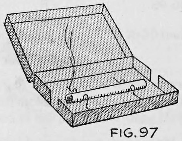 Fig. 97. — An open cardboard cigarette box with air holes, a burning cigarette held up midway inside on bent wire with a thread of smoke rising.