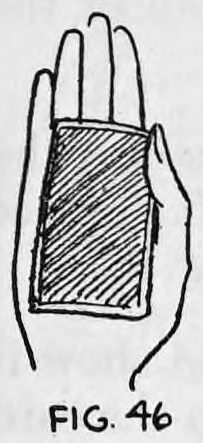 Fig. 46. — The right hand held palm up with the card lying across it, seen from the front as the card is held between thumb and little finger.