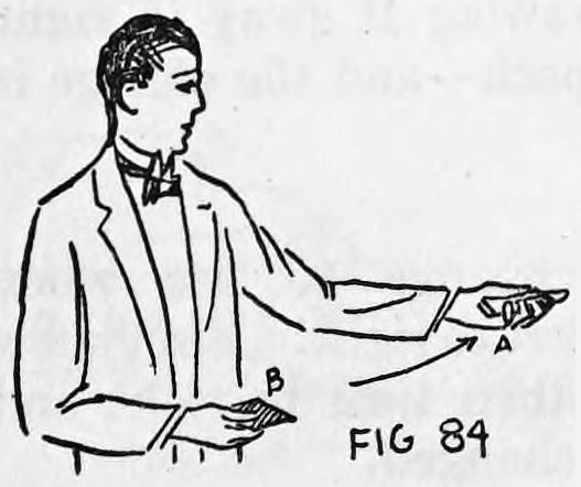 Fig. 84. — The performer holds card B in the right hand with its face hidden, the left hand pointing forefinger while card A rejoins the pack.
