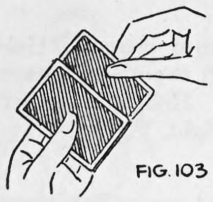 Fig. 103. — A left hand holds the deck face down while the right thumb and fingers take hold of the second card behind and the first card in front at the bottom of the deck.