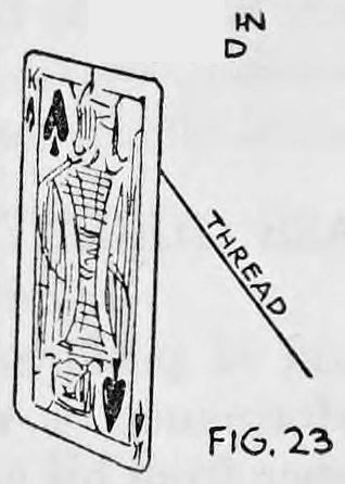 Fig. 23. — A playing card, the King of Spades, with a slit marked in its upper edge and a silk thread running from the slit diagonally down across the face of the card.