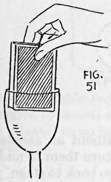Fig. 51. — The deck, faces toward the viewer, is lowered into the glass by the right hand, with the thread hanging below the glass.