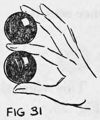 Fig. 31. — The right hand with the shell held between thumb and first finger and the ball raised between first and second fingers, so two balls appear one above the other.