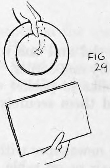 Fig. 29. — The right hand draws the newspaper away from the left, which holds the plate with the silks inside it.