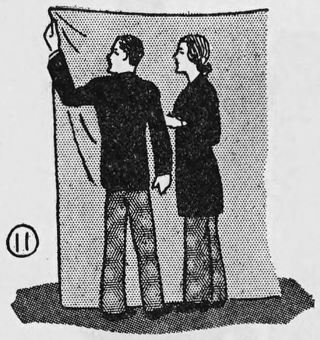 Fig. 11. — Rear view: the assistant and the girl stand side by side behind the hung blanket, the assistant's left hand holding the upper corner.